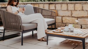 A person seated on a wicker chair with a table in front, overlooking a mountainous landscape. - Sonnenresort Ettershaus (Bad Harzburg)
