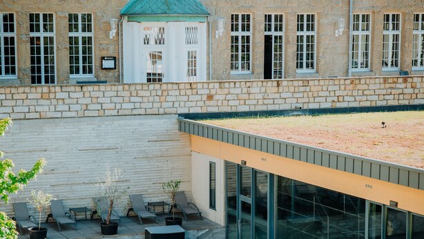 A modern building with a swimming pool, outdoor seating, and a rooftop garden. - Sonnenresort Ettershaus (Bad Harzburg)