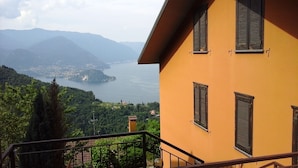 A building with a balcony overlooking a lake and mountains. - Bologna House (Perledo)