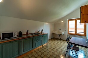 Une cuisine équipée d’un four à micro-ondes, d’une cuisinière et d’un évier. On y trouve également une table à manger avec des chaises.