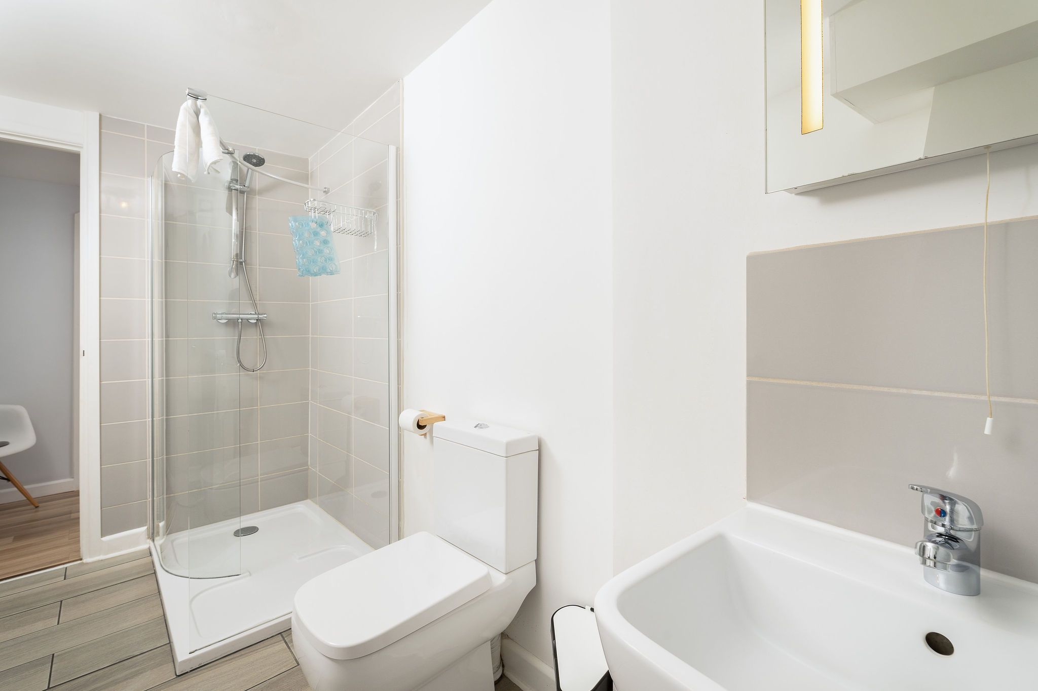 A modern bathroom with a glass shower enclosure, a white toilet, and a bathtub.