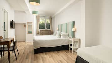 Une chambre à coucher avec un lit, une table de chevet, une lampe et une vue sur l’extérieur.