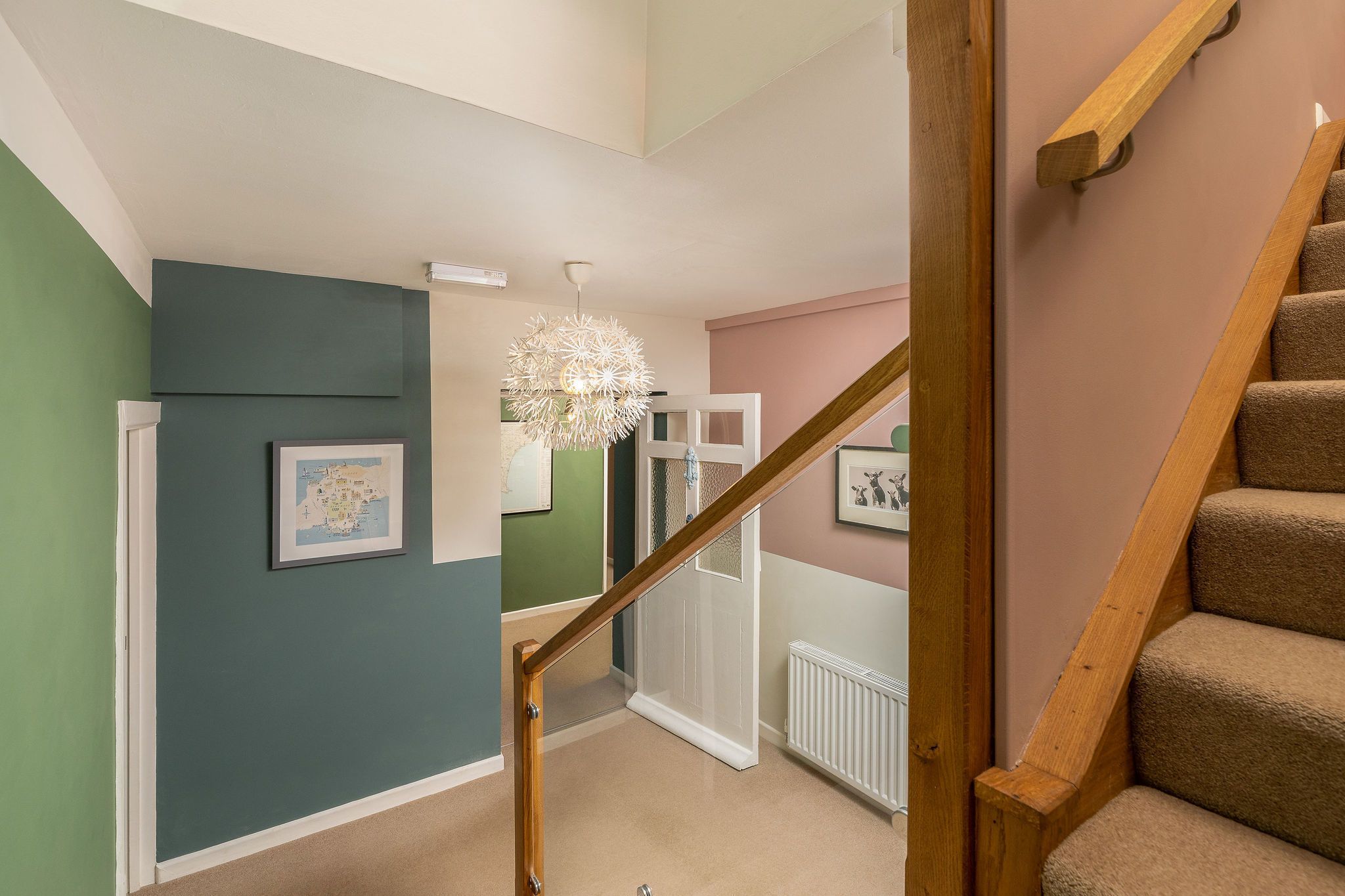 A staircase with wooden handrails and beige carpeted steps.