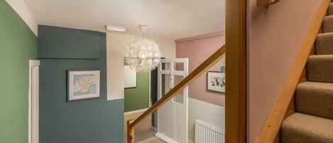 A staircase with wooden handrails and beige carpeted steps.