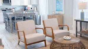 Un salon moderne comprenant un coin repas, une cuisine et une grande fenêtre agrémentée de rideaux.