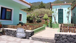 Une propriété appelée « CASAS BEJENADO », dotée d’une entrée avec un mur en pierre, d’une clôture en bois et offrant une vue sur une colline.