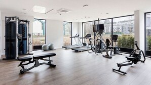 Una palestra moderna con macchinari cardio, attrezzature per sollevamento pesi e una panca.