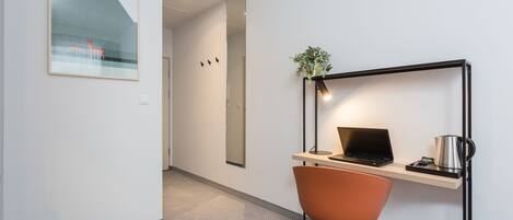 Un espacio de oficina moderno con escritorio, silla y ordenador portátil.