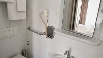 A bathroom with a toilet, sink, and mirror.