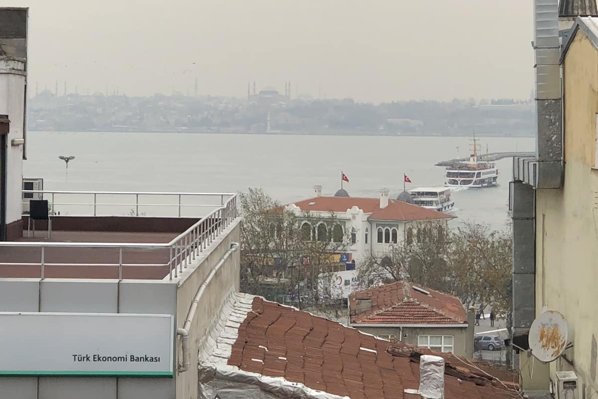 A view of a cityscape with a river, buildings, and a boat.