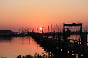 Um cais com barcos atracados ao pôr do sol.