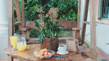 A rustic wooden table with a sign reading "#Villa Solihin" above it, surrounded by greenery.