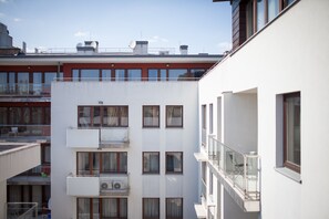 A multi-story residential building with balconies, air conditioning units, and a clear sky. - Quality Point Apartments 0-24 reception (Budapest)