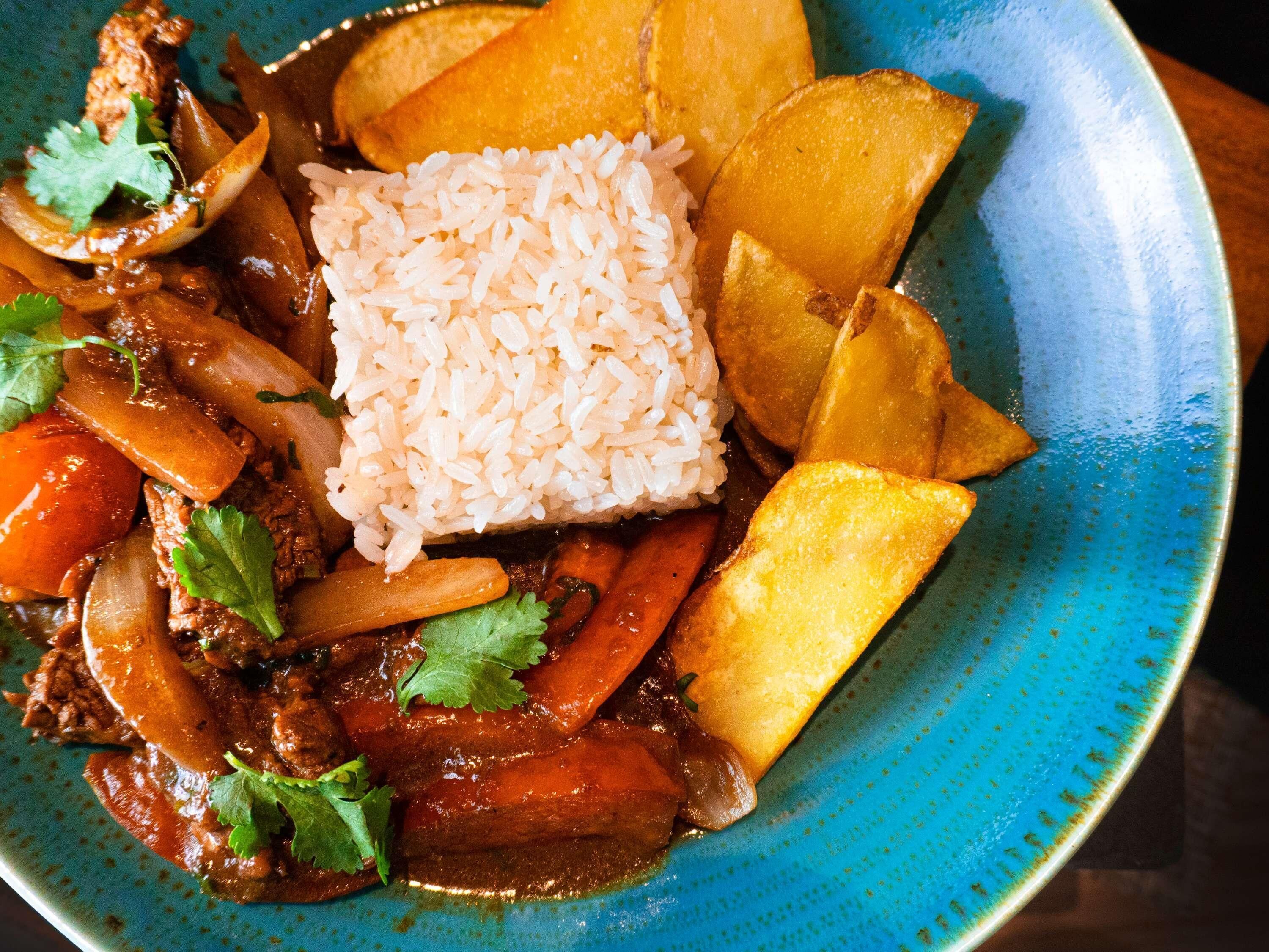 A plate of food with rice, meat, and vegetables.