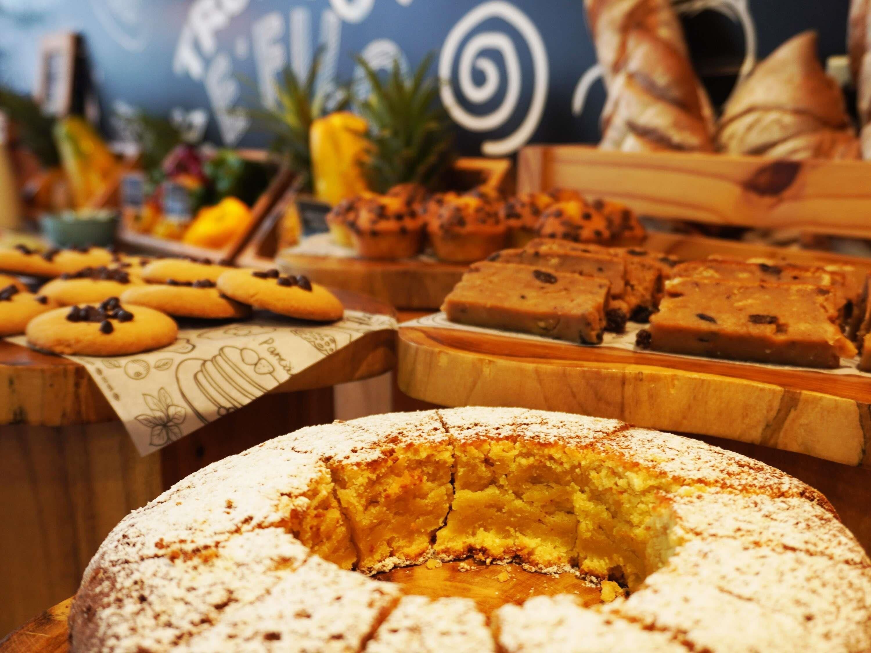 A variety of baked goods including cookies, brownies, and a cake with powdered sugar.