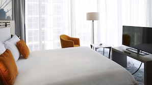 A hotel room with a large bed, a desk with a TV, a chair, and a lamp. - ibis Styles Warszawa City (Warsaw)