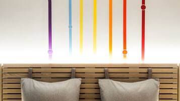 A bed with two pillows, one white and one orange, and a wooden headboard.