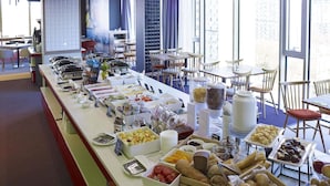 A buffet setup with various food items and a seating area with tables and chairs. - ibis Styles Warszawa City (Warsaw)