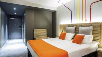 Quarto de hotel moderno com cama grande, cabeceira de madeira e teto iluminado com linhas coloridas.