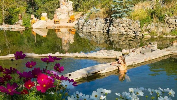 A serene outdoor pool area with a stone wall and a wooden deck. - 1107 Trappeur's Lodge, Trappeur's Crossing Apartment 1 (Steamboat Springs)
