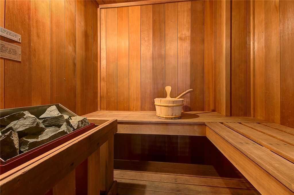 A wooden sauna with benches and a stone basin.