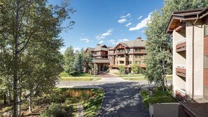 A large, multi-story building with a central entrance, surrounded by trees and a landscaped area. - 1201 Trappeur's Lodge, Trappeur's Crossing Apartment 2 (Steamboat Springs)