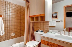 A bathroom with a bathtub, toilet, and sink.