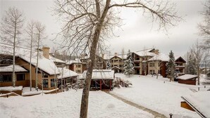 A snow-covered resort with multiple buildings, including a lodge and guest houses, connected by a snow-covered pathway. - 1208 Trappeur's Lodge, Trappeur's Crossing Apartment 1 (Steamboat Springs)