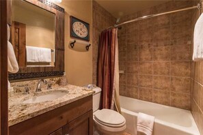 Ein Badezimmer mit Doppelwaschbecken, Toilette und Badewanne.