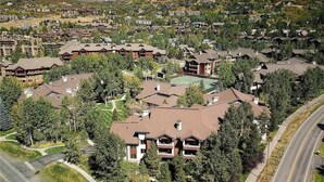 An aerial view of a residential area with multiple two-story houses, a road, and a mountain in the background.