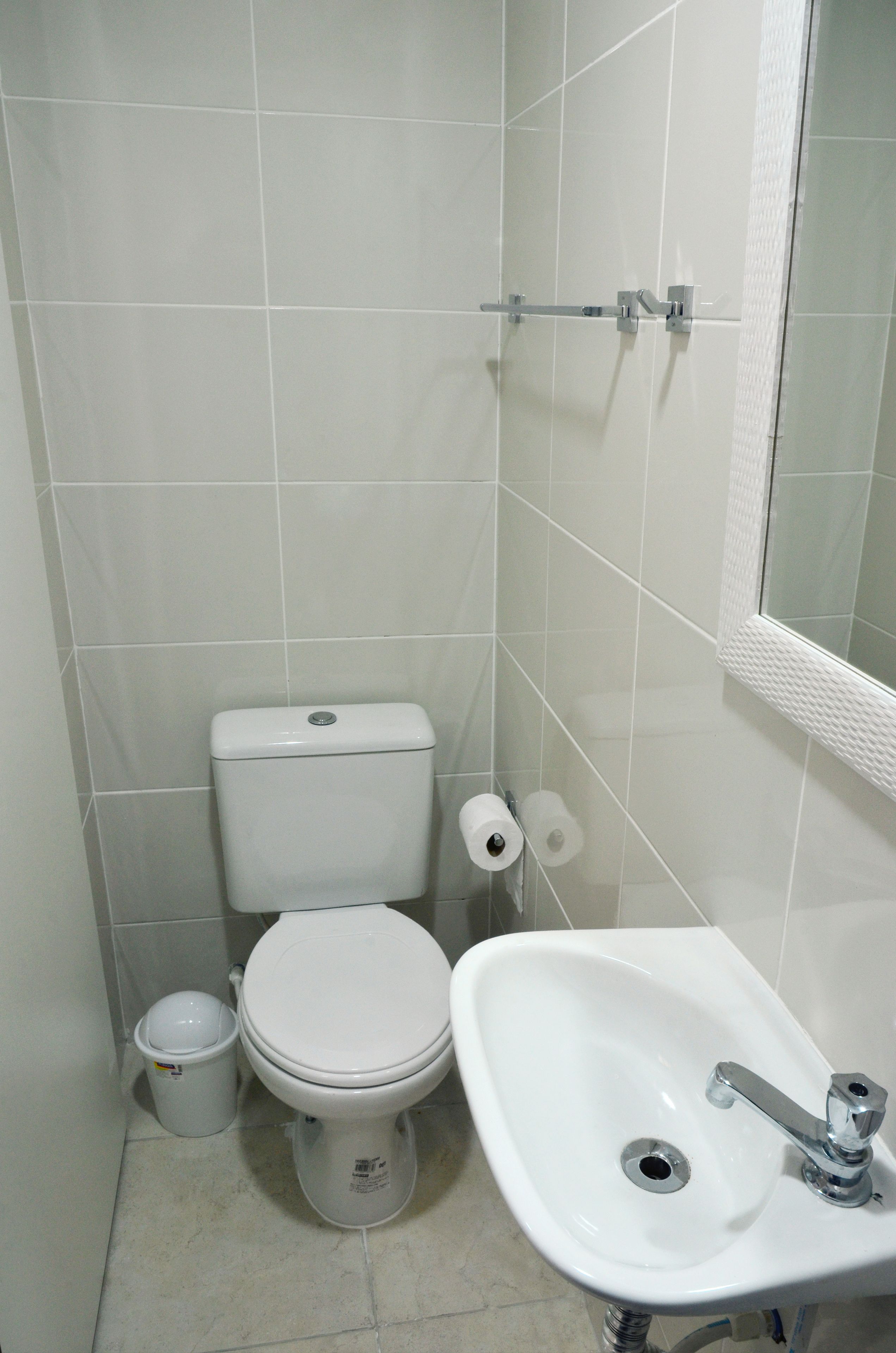 Ein kleines Badezimmer mit Toilette, Waschbecken und Spiegel.