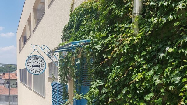 A building with a sign reading "STUDIO ANA LARA SÃO PAULO" and a blue shuttered window. - Studio Ana Laura (São Paulo)