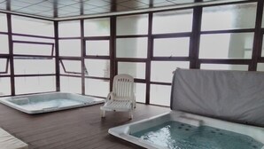 A spa area with two hot tubs and a white chair. - Depto Jardín del Mar La serena 941 (Coquimbo)