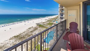 A balcony with a view of a beach and a pool. - Phoenix IV - 1BR Gulf Front! - Condo 4082 (Orange Beach)