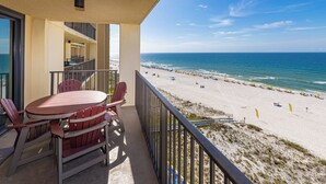 A balcony with a view of a beach, a table with chairs, and a railing. - Phoenix IV - 1BR Gulf Front! - Condo 4082 (Orange Beach)