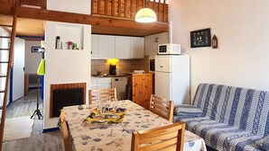 A compact kitchen with white cabinets, a microwave, and a hanging light fixture. - 2 Room Mais., Pool, BBQ, Near the Sea (Bretignolles-sur-Mer)