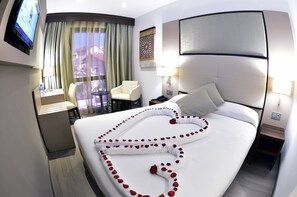 A hotel room with a large bed, a TV, a desk with a chair, and a view of the outside. - AZ Hôtel Vieux Kouba (Algiers)