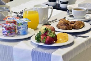 A breakfast setup with yogurt, fruit, orange juice, coffee, and pastries on a table. - AZ Hôtel Vieux Kouba (Algiers)
