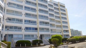 A multi-story building with a modern architectural design, featuring a series of balconies and large windows.