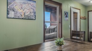 A dining area with a wooden table, chairs, a potted plant, and a large map on the wall. - Ski in Ski out, well appointed 4 bed, 4 bath, with hot tub and lake views! (Sandpoint)