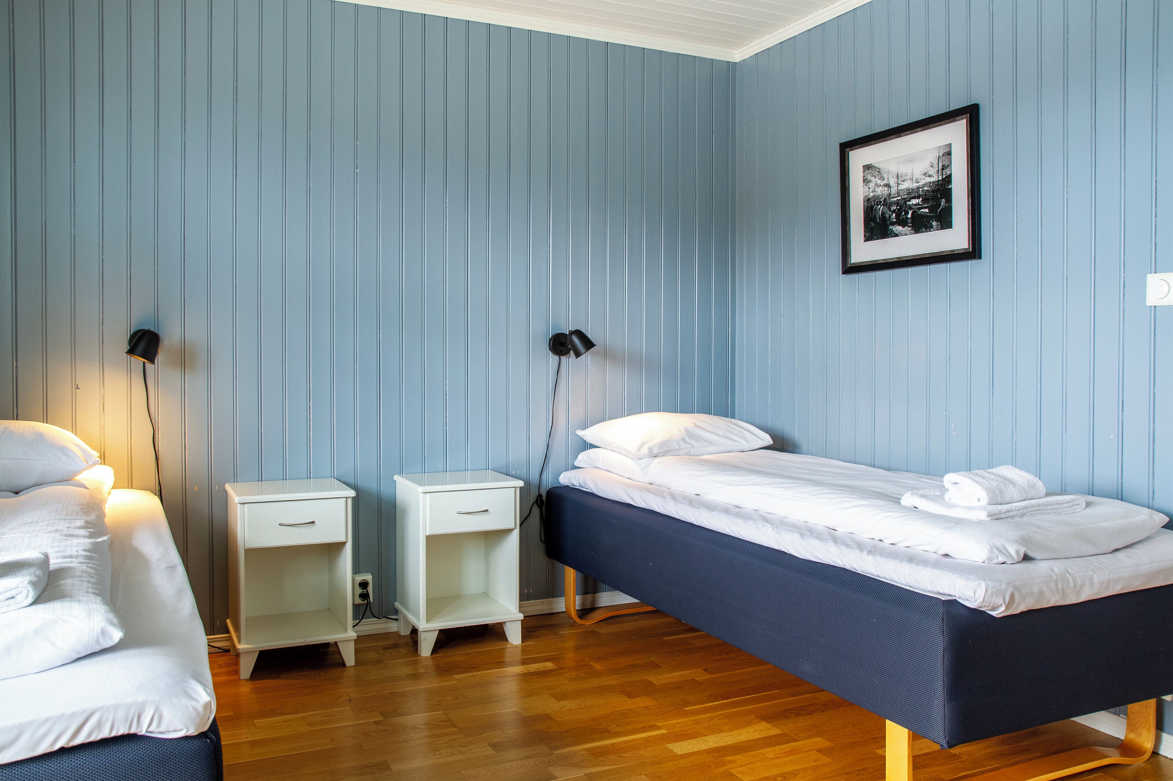 Une chambre avec un lit simple, une table de chevet et une commode.