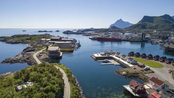 A coastal town with a marina, houses, and a prominent mountain in the background.