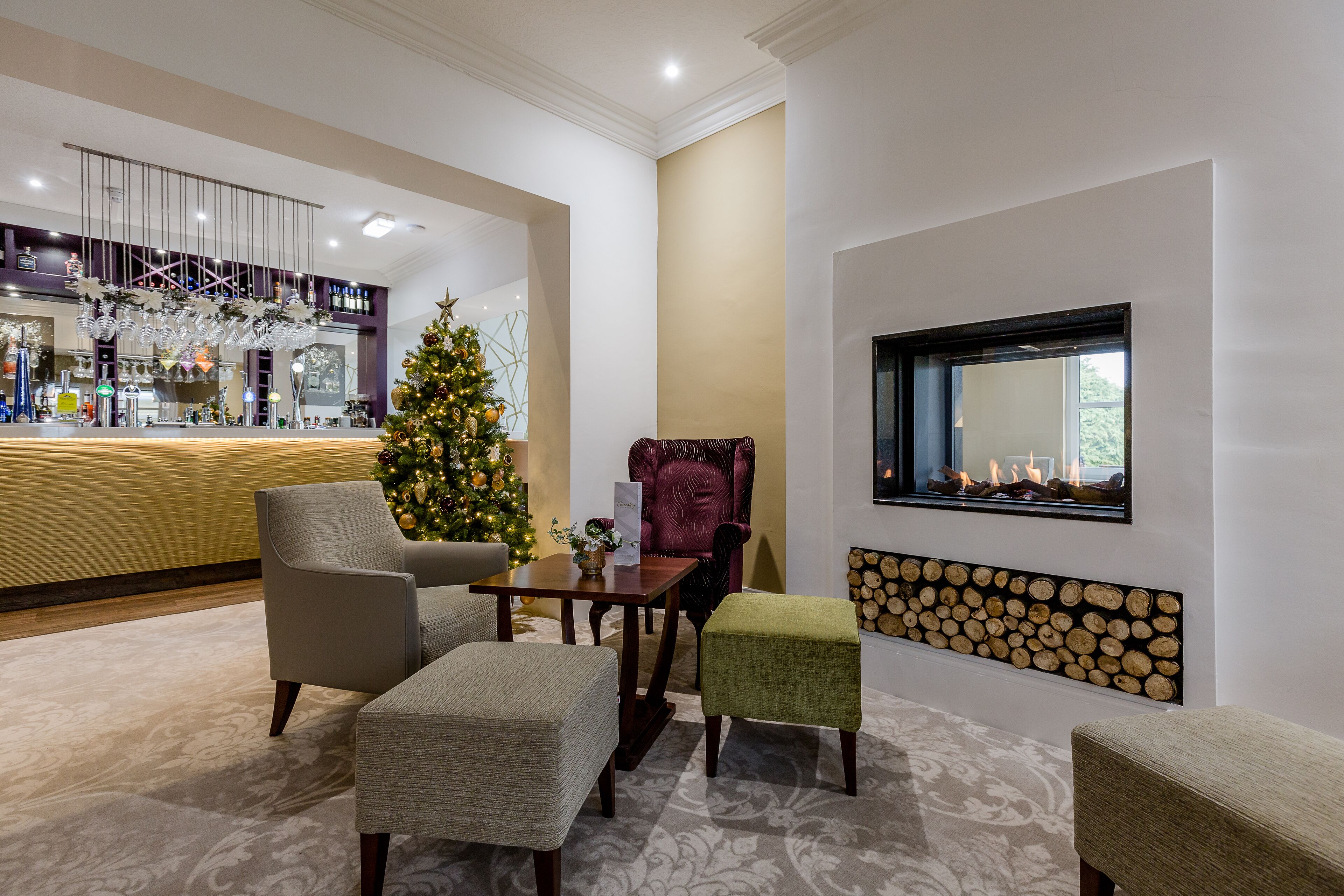 Eine Lobby mit Weihnachtsbaum, Sitzgelegenheiten und Kamin.