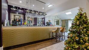 A bar area with a counter, chairs, and a Christmas tree. - The Melbreak Hotel (Workington)