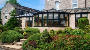 The Melbreak Hotel with stone facade, large windows, and well-maintained gardens. - The Melbreak Hotel (Workington)