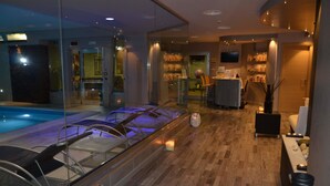 A modern spa area with a pool, lounge chairs, and a reception desk. - Mediterraneo Palace Depandance (Amantea)