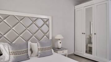 A hotel room with a bed, a nightstand with a lamp, and a wardrobe.