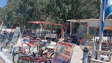 A parking area with bicycles and a signboard advertising a family bicycle tour.