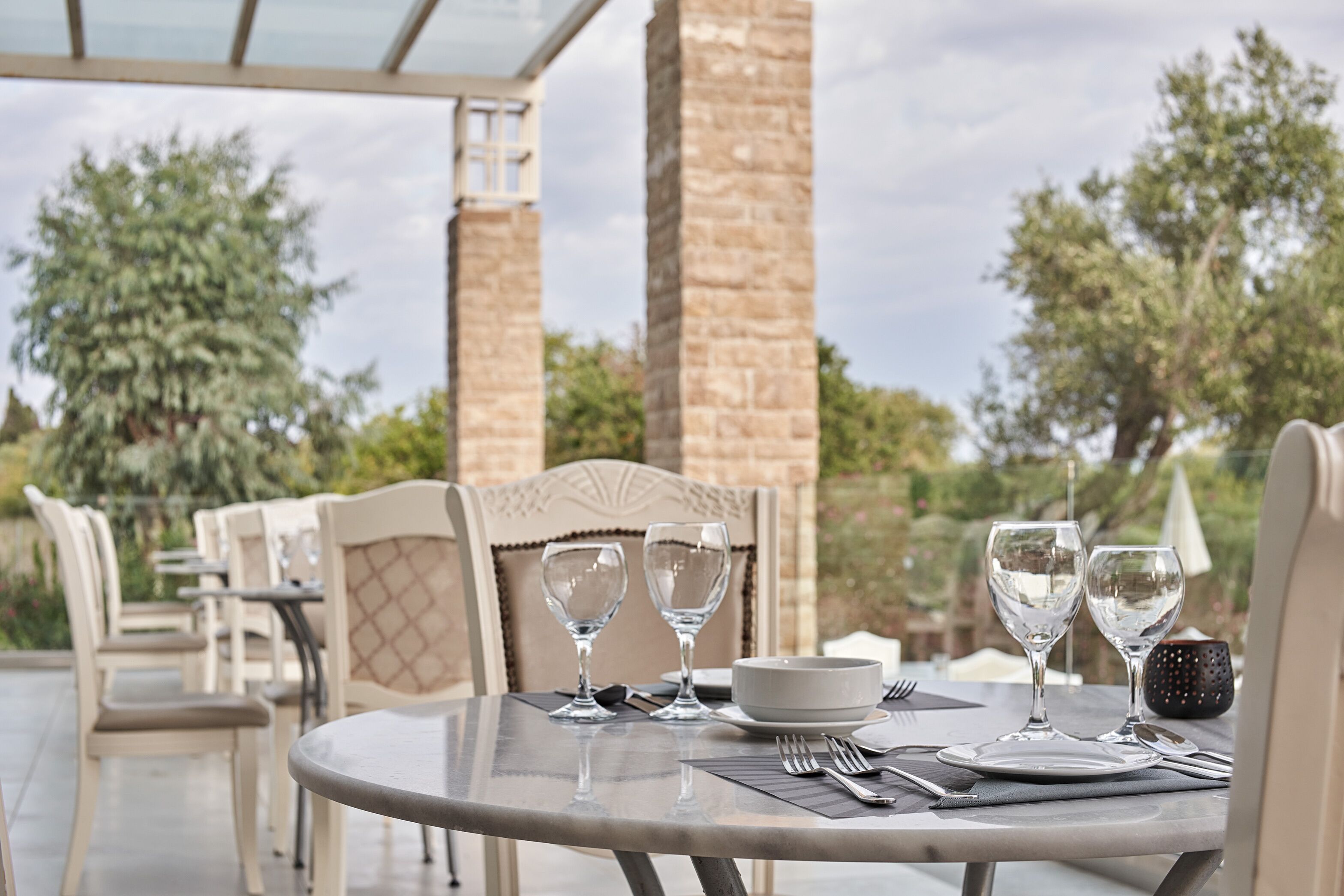 A table set for two with wine glasses, a bowl, and cutlery.