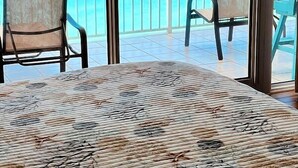 Ein Balkon mit zwei Stühlen und einem Tisch, mit Blick auf das klare, blaue Meer.